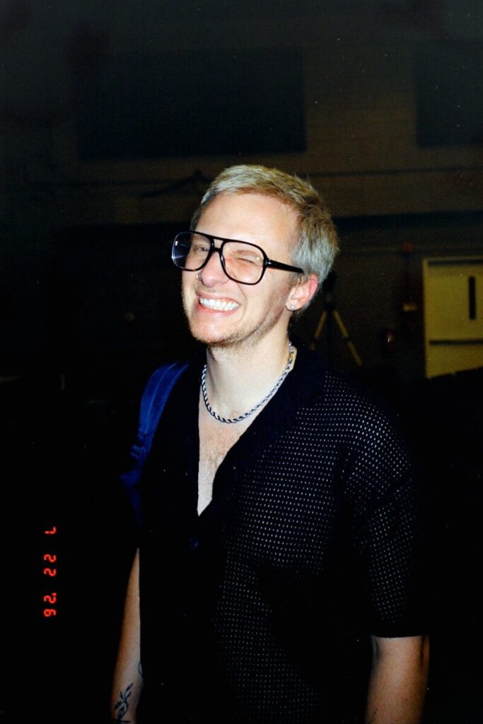 Blond man with glasses smiling broadly